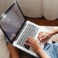 Seseorang sedang fokus menggunakan laptopnya, menampilkan berbagai ikon media sosial yang melambangkan penggunaan platform digital untuk tujuan produktif dan pengembangan diri. Gambar ini merepresentasikan potensi media sosial sebagai alat yang mendukung pertumbuhan pribadi dan profesional.