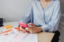 Seorang pemilik usaha kecil sedang serius menghitung keuangan bisnisnya, menunjukkan dedikasi dalam mengelola setiap detail transaksi. Momen ini merefleksikan pentingnya pencatatan akurat bagi kesehatan finansial UMKM.
