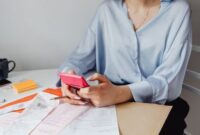 Seorang pemilik usaha kecil sedang serius menghitung keuangan bisnisnya, menunjukkan dedikasi dalam mengelola setiap detail transaksi. Momen ini merefleksikan pentingnya pencatatan akurat bagi kesehatan finansial UMKM.