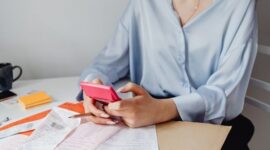 Seorang pemilik usaha kecil sedang serius menghitung keuangan bisnisnya, menunjukkan dedikasi dalam mengelola setiap detail transaksi. Momen ini merefleksikan pentingnya pencatatan akurat bagi kesehatan finansial UMKM.