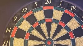 Ilustrasi papan panahan yang menyoroti pusat target, melambangkan akurasi dalam menentukan target pasar yang tepat sasaran untuk keberhasilan bisnis. Gambar ini merefleksikan pentingnya fokus pada konsumen ideal agar setiap upaya pemasaran memberikan hasil maksimal.