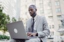 Seorang pelaku UMKM sedang fokus menggunakan laptop untuk mendaftar NIB secara online melalui sistem OSS, menunjukkan kemudahan akses digital dalam melegalkan usaha. Proses ini penting untuk mendapatkan identitas resmi bisnis dan membuka berbagai peluang pengembangan di masa depan.