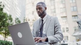 Seorang pelaku UMKM sedang fokus menggunakan laptop untuk mendaftar NIB secara online melalui sistem OSS, menunjukkan kemudahan akses digital dalam melegalkan usaha. Proses ini penting untuk mendapatkan identitas resmi bisnis dan membuka berbagai peluang pengembangan di masa depan.