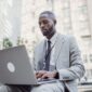 Seorang pelaku UMKM sedang fokus menggunakan laptop untuk mendaftar NIB secara online melalui sistem OSS, menunjukkan kemudahan akses digital dalam melegalkan usaha. Proses ini penting untuk mendapatkan identitas resmi bisnis dan membuka berbagai peluang pengembangan di masa depan.