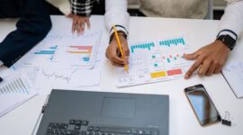 Seorang pebisnis wanita modern sedang menganalisis data grafik pada layar tablet, menunjukkan pentingnya pemanfaatan teknologi untuk pertumbuhan bisnis di era digital. Gambar ini merefleksikan proses pengambilan keputusan berbasis data yang krusial dalam mengembangkan strategi bisnis digital.