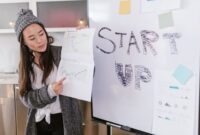 Seorang wirausahawan muda sedang mempresentasikan ide bisnisnya dengan penuh semangat, menunjukkan bahwa kreativitas dan inovasi bisa menjadi modal utama dalam merintis usaha. Ia menggunakan gestur tangan untuk menekankan poin penting dalam presentasinya.