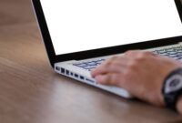 Ilustrasi tangan yang sedang mengoperasikan laptop menunjukkan proses pendaftaran bisnis secara daring, menggambarkan kemudahan akses sistem perizinan Online Single Submission (OSS) bagi pelaku usaha. Ini merefleksikan efisiensi dalam memperoleh Nomor Induk Berusaha (NIB) sebagai legalitas penting bagi keberlangsungan bisnis di era digital.