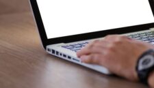 Ilustrasi tangan yang sedang mengoperasikan laptop menunjukkan proses pendaftaran bisnis secara daring, menggambarkan kemudahan akses sistem perizinan Online Single Submission (OSS) bagi pelaku usaha. Ini merefleksikan efisiensi dalam memperoleh Nomor Induk Berusaha (NIB) sebagai legalitas penting bagi keberlangsungan bisnis di era digital.