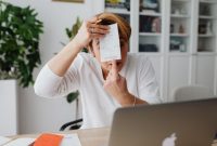 Seorang pemilik usaha kecil sedang serius memeriksa laporan keuangan pada laptopnya, menunjukkan dedikasinya dalam mengelola setiap aspek finansial demi keberlangsungan bisnis. Manajemen keuangan yang cermat menjadi kunci utama bagi para pelaku UMKM untuk menghadapi tantangan ekonomi.